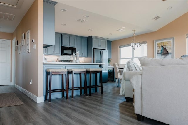 299 Bay Dr, Palacios, TX 77465 - kitchen featuring black microwave, a peninsula, light countertops, dark wood-type flooring, and open floor plan