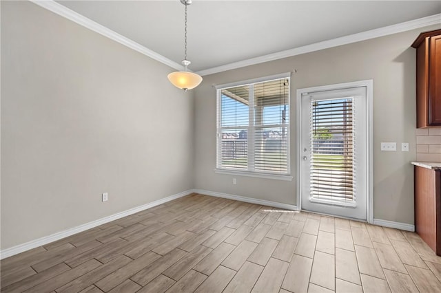 unfurnished dining area with light wood-style floors, baseboards, and ornamental molding