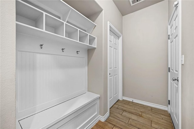 mudroom featuring visible vents, baseboards, and wood finish floors