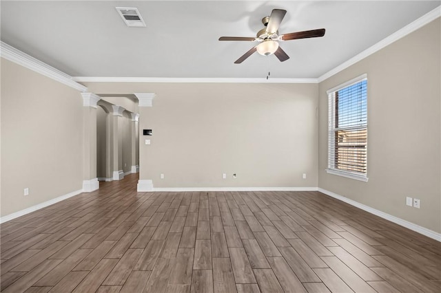 spare room featuring wood finished floors, ceiling fan, baseboards, and visible vents