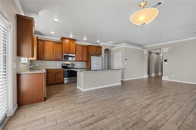kitchen with open floor plan, backsplash, visible vents, appliances with stainless steel finishes, and a sink