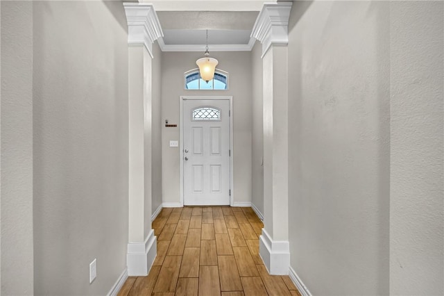 entryway with crown molding, wood finished floors, and baseboards