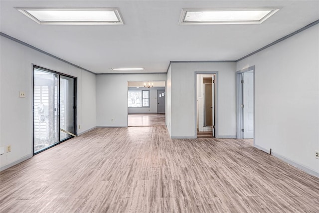 empty room with an inviting chandelier, crown molding, and light hardwood / wood-style floors