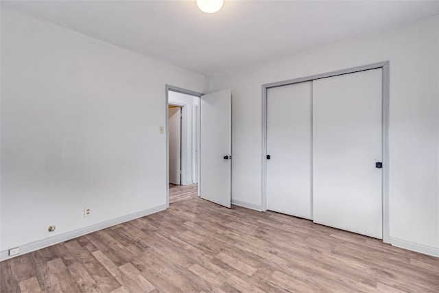 unfurnished bedroom featuring a closet and light hardwood / wood-style flooring