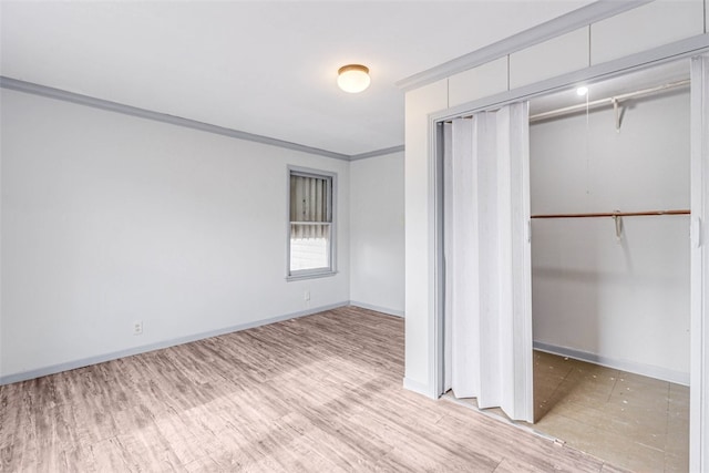 unfurnished bedroom with a closet, ornamental molding, and light hardwood / wood-style flooring