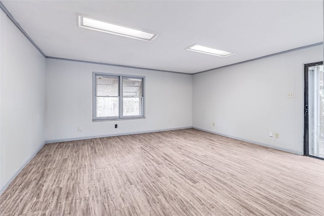 spare room with light hardwood / wood-style floors and crown molding