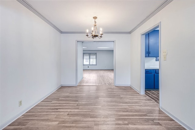 unfurnished dining area featuring light hardwood / wood-style flooring, ornamental molding, and a chandelier