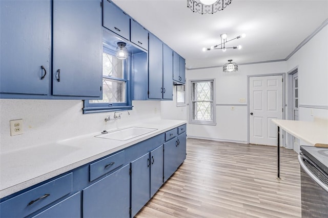 kitchen featuring stainless steel electric range oven, light hardwood / wood-style floors, blue cabinets, crown molding, and sink