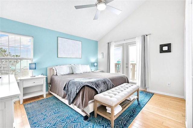 bedroom with access to outside, multiple windows, vaulted ceiling, and wood finished floors