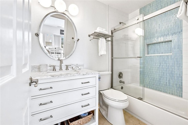 bathroom featuring combined bath / shower with glass door, vanity, toilet, and tile patterned floors