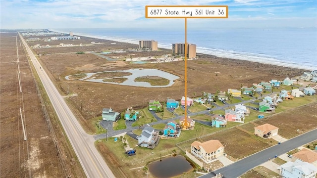 drone / aerial view with a water view and a beach view