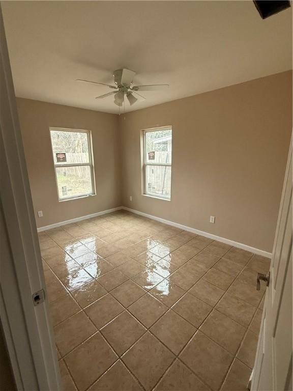 tiled spare room featuring ceiling fan and plenty of natural light