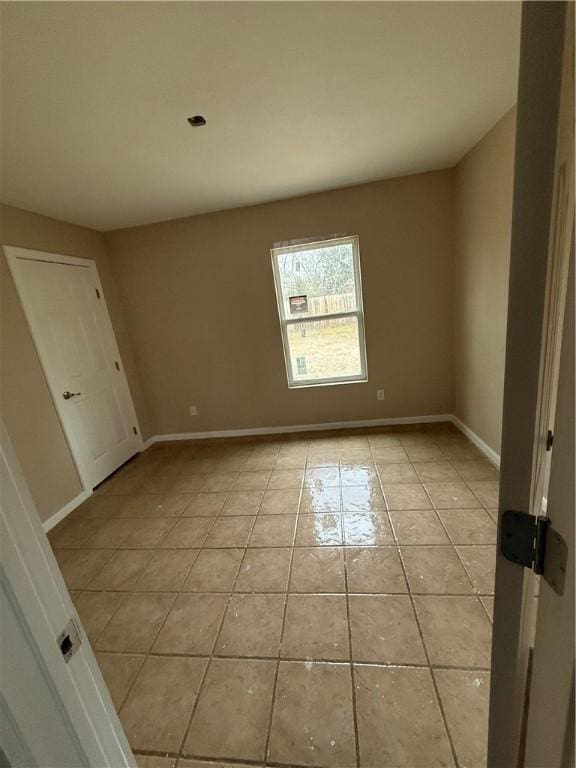 unfurnished room with light tile patterned flooring