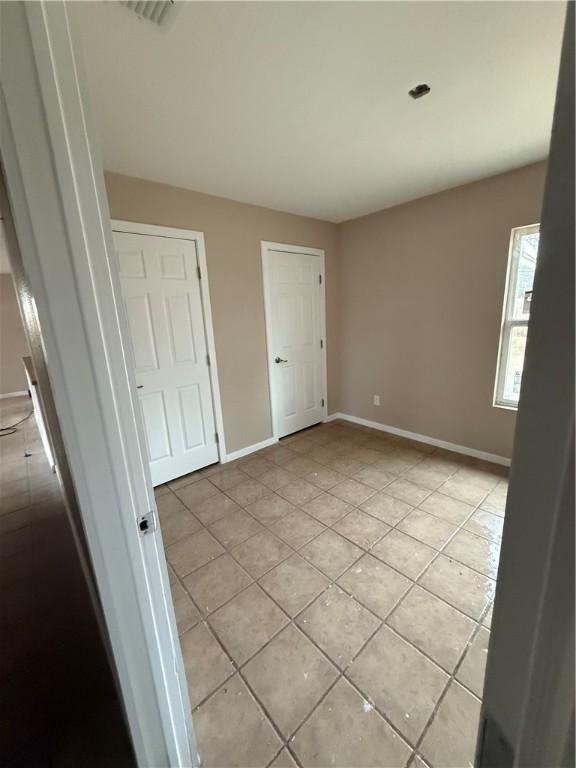 unfurnished bedroom with light tile patterned floors