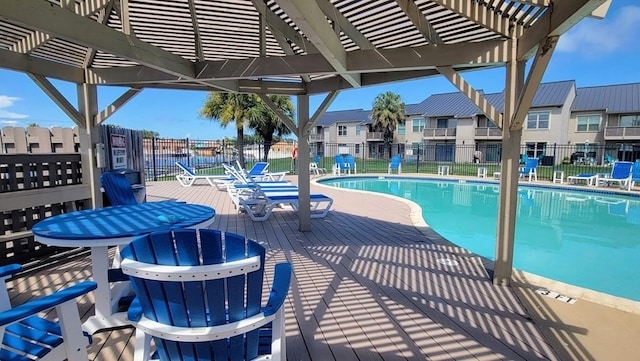 community pool with fence, a residential view, and a pergola