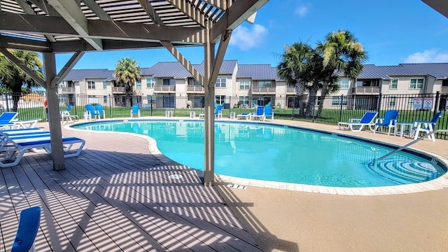 pool featuring a residential view, a patio area, and fence