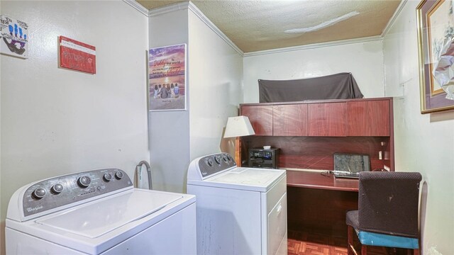 clothes washing area featuring ornamental molding, washing machine and dryer, a textured ceiling, and light parquet floors