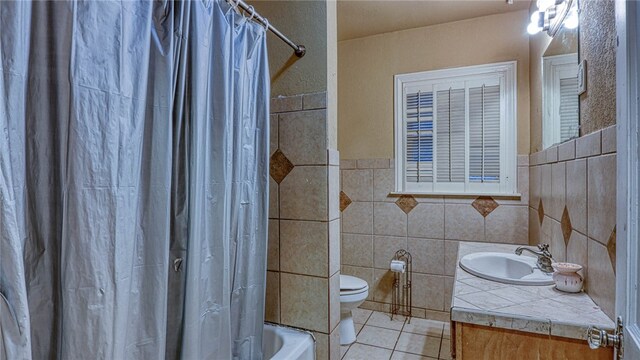 full bathroom with tile walls, tile patterned floors, vanity, toilet, and shower / bath combo with shower curtain