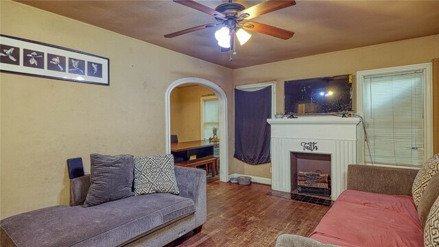 living room with dark wood-type flooring and ceiling fan