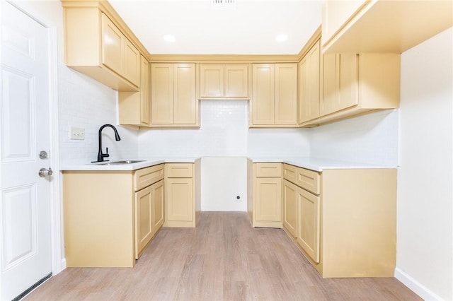 641 Caddo St, Corpus Christi, TX 78412 - kitchen with light wood-type flooring, backsplash, a sink, and light countertops