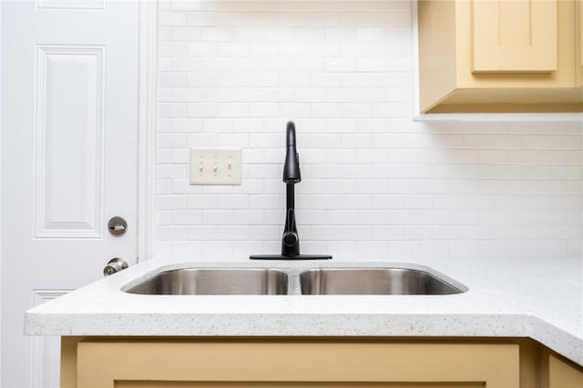 641 Caddo St, Corpus Christi, TX 78412 - kitchen view of a sink, decorative backsplash, and light stone counters