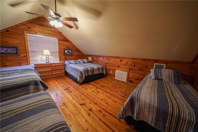 bedroom featuring vaulted ceiling, a textured ceiling, ceiling fan, and light hardwood / wood-style floors