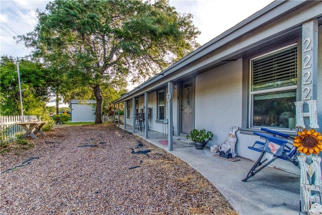 2222 S Commercial St, Aransas Pass, TX 78336 - view of property exterior with stucco siding, a shed, and a patio area