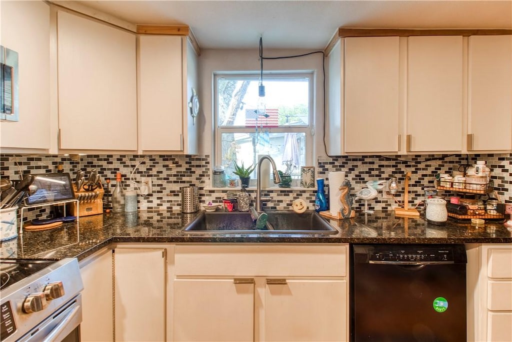 2222 S Commercial St, Aransas Pass, TX 78336 - kitchen with dishwasher, stainless steel range with electric cooktop, tasteful backsplash, and dark stone countertops