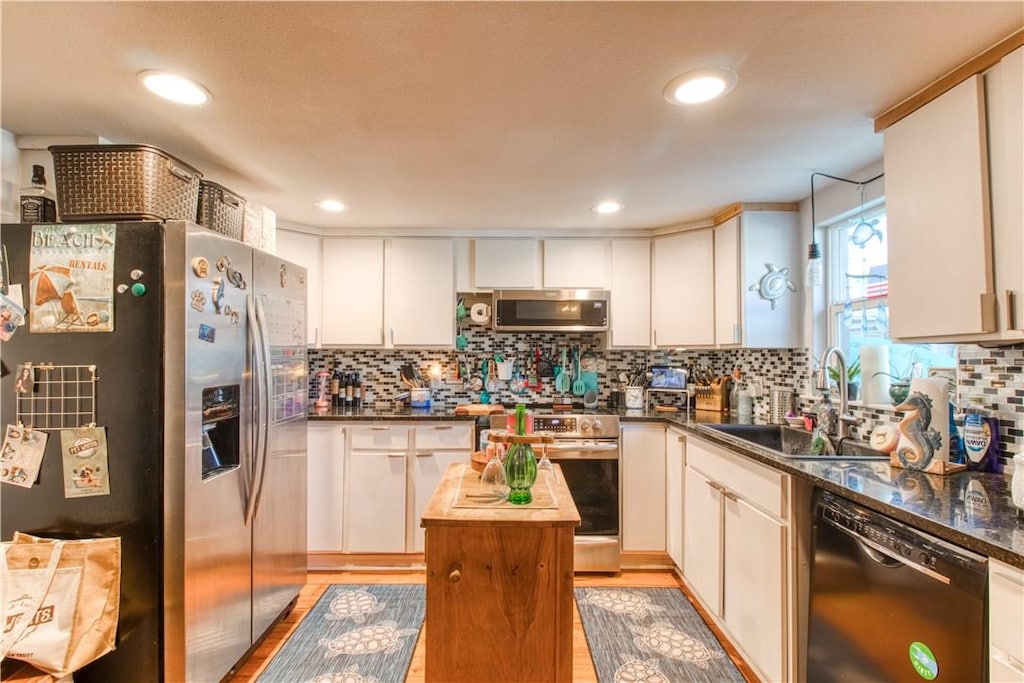 2222 S Commercial St, Aransas Pass, TX 78336 - kitchen with appliances with stainless steel finishes, light wood finished floors, decorative backsplash, white cabinetry, and recessed lighting