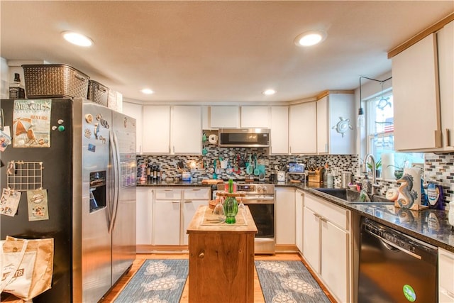2222 S Commercial St, Aransas Pass, TX 78336 - kitchen with appliances with stainless steel finishes, light wood finished floors, decorative backsplash, white cabinetry, and recessed lighting
