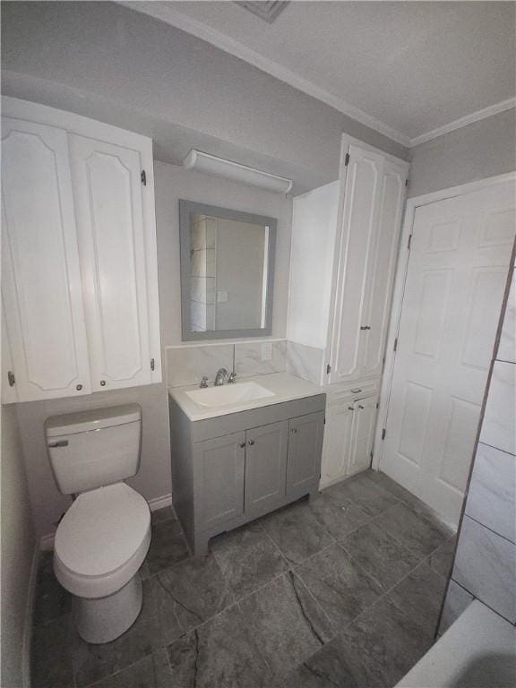 bathroom with vanity, crown molding, and toilet