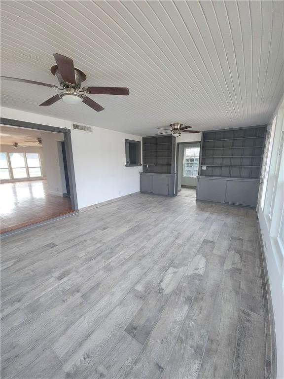 unfurnished living room featuring wood ceiling, wood-type flooring, and ceiling fan