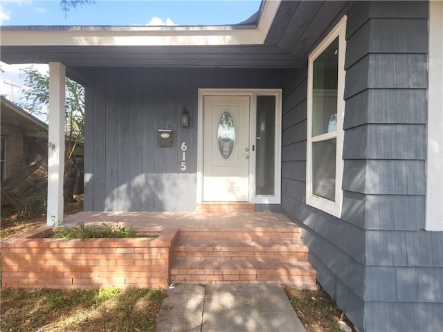 view of exterior entry featuring covered porch