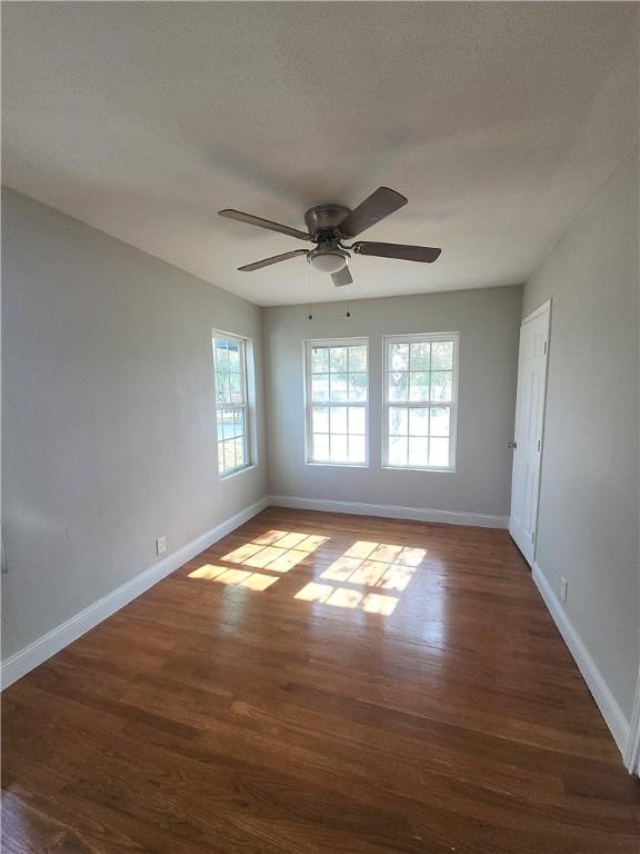 spare room with dark hardwood / wood-style floors and ceiling fan