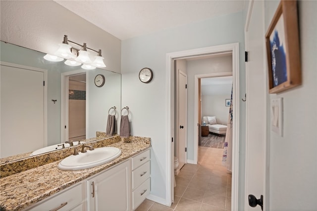 bathroom featuring toilet, vanity, and tile patterned floors