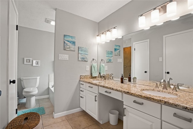 bathroom featuring a textured ceiling, vanity, a bathing tub, tile patterned floors, and toilet