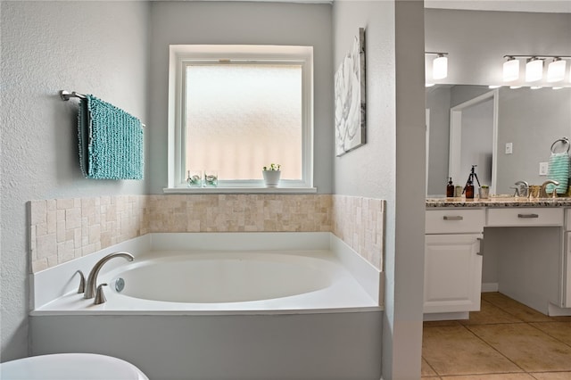 bathroom featuring a bathing tub, tile patterned flooring, and vanity