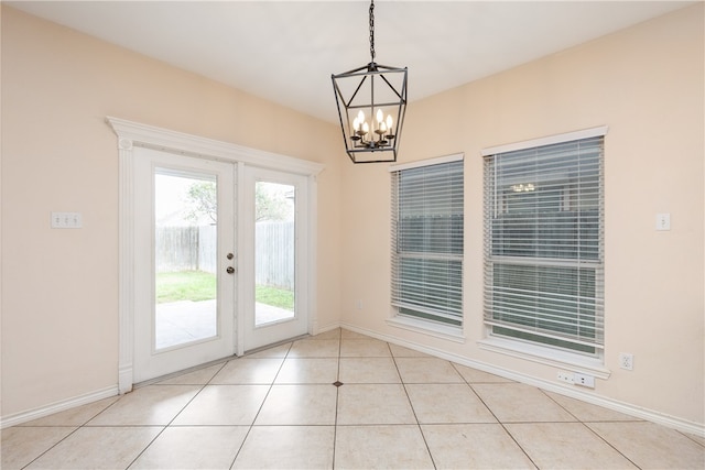 doorway to outside with light tile patterned floors and a chandelier