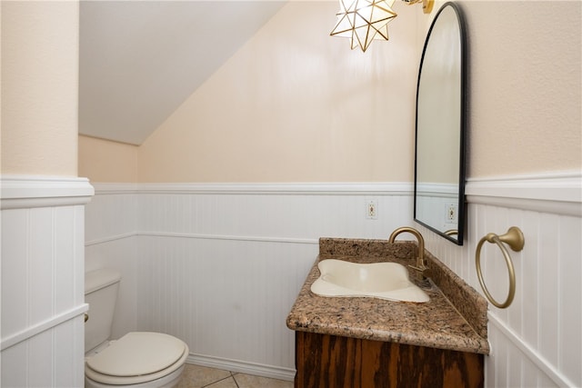 bathroom with tile patterned floors, vanity, toilet, and a chandelier