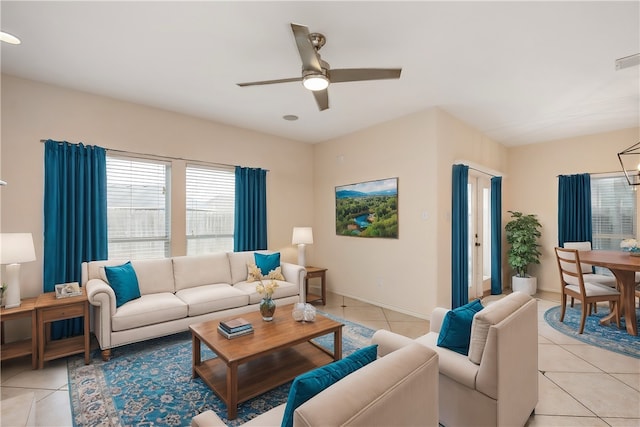 living room with ceiling fan with notable chandelier and light tile patterned floors