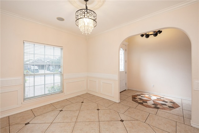 tiled spare room with a chandelier and crown molding