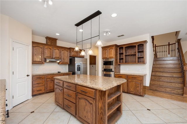 kitchen featuring light tile patterned flooring, appliances with stainless steel finishes, backsplash, a kitchen island, and pendant lighting