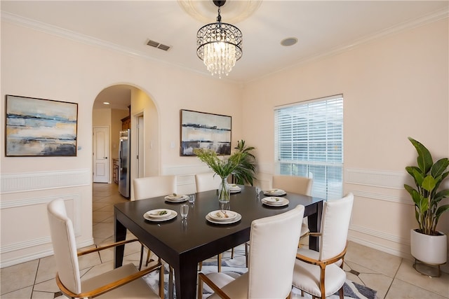 tiled dining room featuring a notable chandelier and ornamental molding