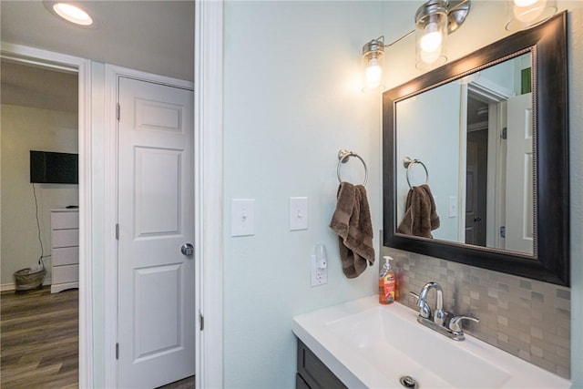 bathroom with vanity, hardwood / wood-style floors, and decorative backsplash