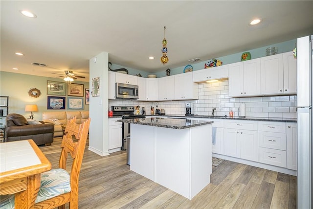 kitchen featuring sink, white cabinets, ceiling fan, light hardwood / wood-style floors, and appliances with stainless steel finishes