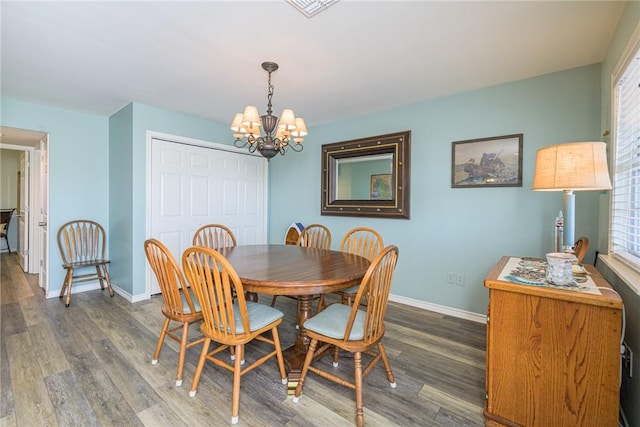 dining room with an inviting chandelier, a healthy amount of sunlight, and dark hardwood / wood-style floors