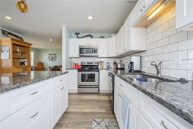 kitchen with sink, stainless steel appliances, and white cabinetry