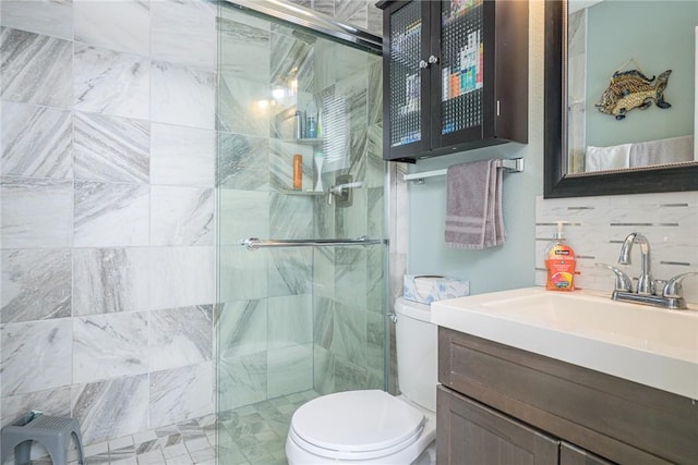 bathroom with a shower with door, backsplash, vanity, and toilet