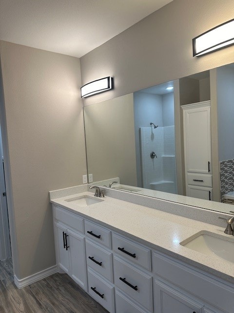 bathroom featuring wood-type flooring, vanity, and walk in shower