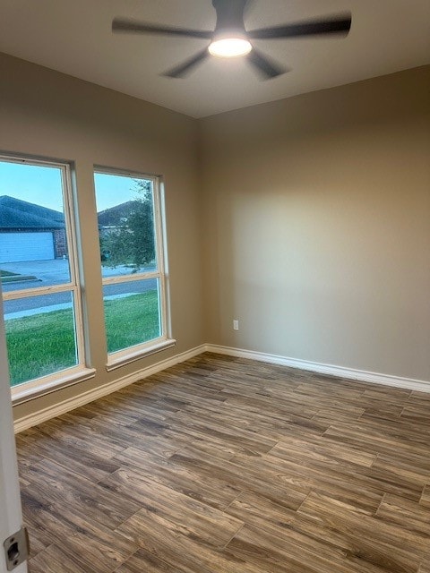 empty room with ceiling fan and dark wood-type flooring